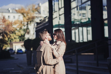 Obraz premium young couple hugging in a coat on a sunny day