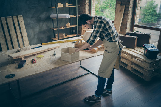 Top above high angle full length photo of focused professional workman use screwdriver fix shelf on tabletop in home house garage