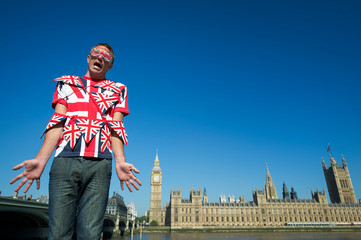 Confused British man tangled in colorful Union Jack bunting standing in front of the city skyline at Westminster, London, UK - obrazy, fototapety, plakaty
