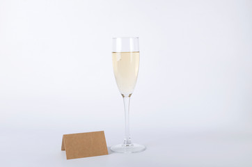 One glass of wine and blank place card on the white background.Empty space for design