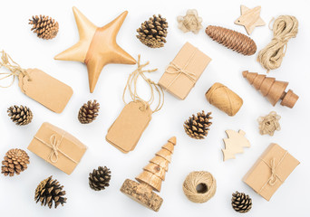 Creative Christmas frame background in the shades of brown on white. Top view of gift boxes, various accessories, wooden decorations, pinecones, tags, selective focus