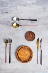 Flat lay of wooden plate and cutlery utensils on grey background. Empty plate. ,food, zero waste...