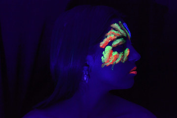 Young woman portrait with fluorescence make up an uv light