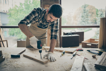 Portrait of his he nice attractive serious focused hardworking experienced guy repairman drilling creating new house building project order gift shop at modern industrial loft style interior