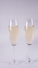 Two glasses with champagne on a white background