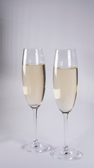 Two glasses with champagne on a white background