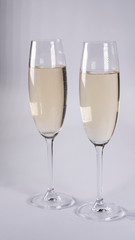 Two glasses with champagne on a white background
