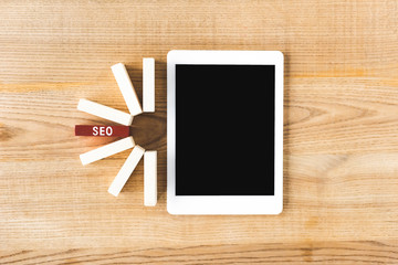 top view of wooden rectangles with lettering seo and digital tablet with copy space on table