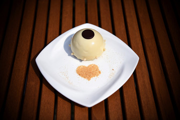 Beautifully decorated cake on a plate. Interestingly arranged dessert.