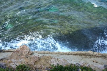 Sea waves crashing on rock coast with spray and foam