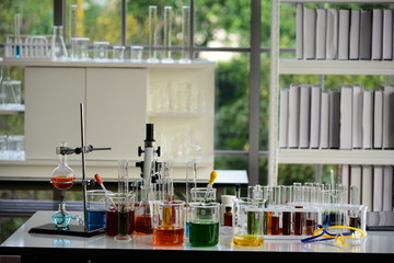 Many chemical laboratory glassware and equipment in scientific laboratory room.