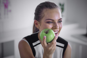 Young beautiful smiling girl with a green apple in hands