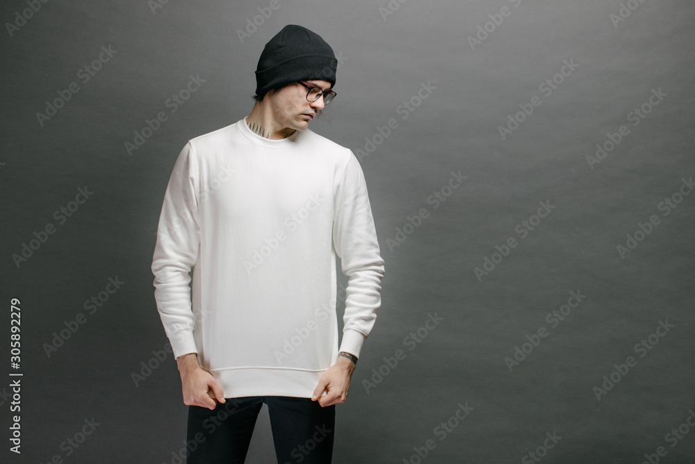 Canvas Prints man wearing white sweatshirt and a black hat standing over gray background. sweatshirt or hoodie for