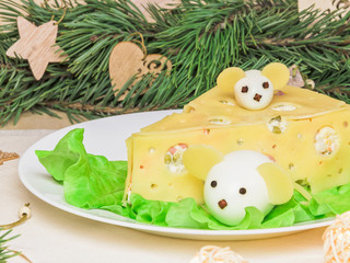 Holiday Christmas salad mouse 2020 New Year cheese piece shape on a white plate. Boiled eggs with cheese look like white mice (rats), horizontal, close up