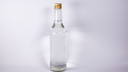 Fototapeta premium Bottle with a clear liquid, vodka on a white background