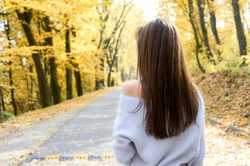 Portrait of brunette woman in casual wear in autumn park. Yellow colours around beautiful woman