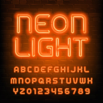 Neon Light alphabet font. Simple orange neon letters and numbers. Brick wall background. Stock vector typescript for your typography design.