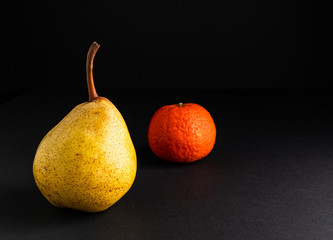 Ripe pear isolated on black background. Dark food photography with copy space.