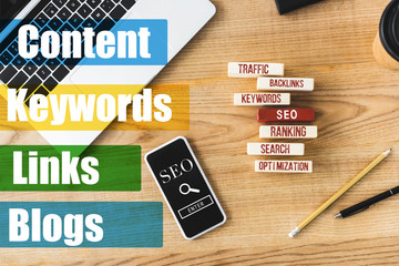 top view of wooden rectangles with illustration of concept words of seo, smartphone, laptop, pen...