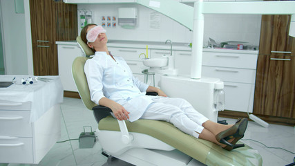 Obraz premium Doctor relax on a dental chair in cabinet