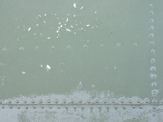 Old green metal surface of the aircraft fuselage with rivets