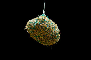 Hay bales suspended in a net on a chain