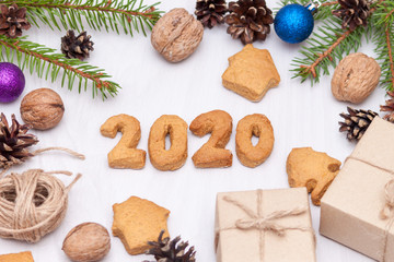 Christmas composition. Xmas gingerbread cookies, cookies in shape of numbers 2020,  fir branches, gifts on white background. New year 2020. Flat lay, top view.