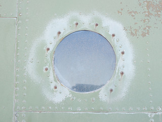 Old green metal surface of the aircraft fuselage with rivets