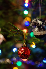 Part of christmas decorating house interior. Branch of xmas fir tree Illuminated garland. Xmas bauble toy closeup.