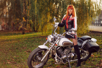Plakat cruiser motorcycle and woman biker in the autumn city