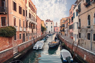 Canal with floating boats between the colorful houses