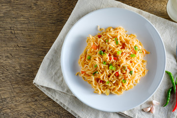 A cup of instant noodles placed on a napery With chilli as ingredients ,top view noodle and copy space