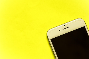 white smartphone on a yellow background close-up