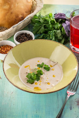 stew chicken in creamy sauce with parsley and glass of red drink on blue wooden table