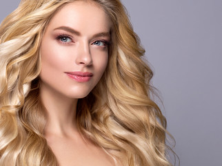 Naklejka premium Blonde woman long curly hair face close up beautiful female natural makeup