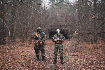 Naklejka premium Two soldiers with machine guns and gas masks on the background of a missile bunker during the Soviet Union