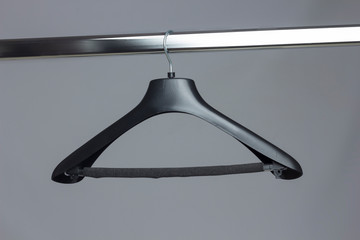 Perchas de la ropa colgadas de un perchero. Percha de plástico y percha de maderas, vacías de ropa