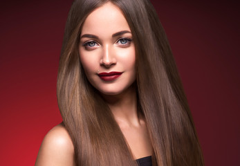 Fototapeta premium Woman beautiful make up face female red lops long smooth hair red dark background