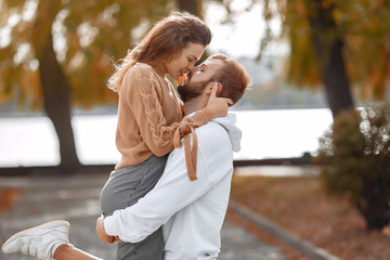 Couple in a park. Woman in a brown sweaterr. Man with a beard