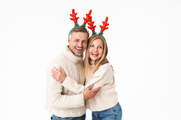 Image of beautiful couple in Christmas reindeer antlers headbands smiling