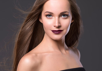 Naklejka premium Beautiful hairstyle woman face long smooth brunette hair red lips over gray background