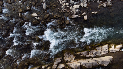 Drone shooting above the fast flowing water of a mountain river.
