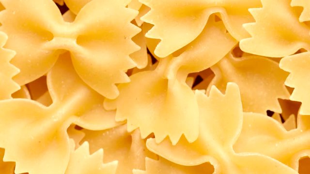 Pile of raw italian farfalle pasta rotating in circle