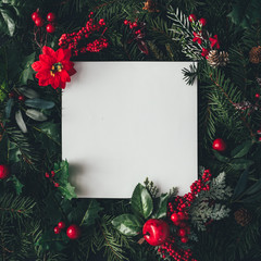 Creative layout made of Christmas tree branches and fruits with paper card note. Flat lay. Nature holiday festive concept. Greeting card with copy space.