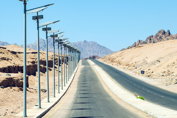 High poles with lanterns on top, street lamp along the road in Egypt