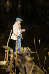 Boy Catching a Fish from wooden dock.