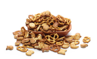 Salty cracker and pretzel snacks, party mix in clay bowl, pot isolated on white background