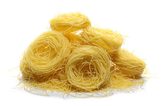 Dry, raw egg pasta noodles, isolated on white background