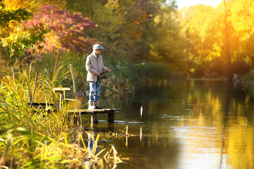 boy catching a fish with fishing rod