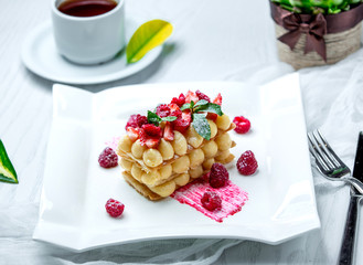 french dessert garnished with strawberry and raspberry